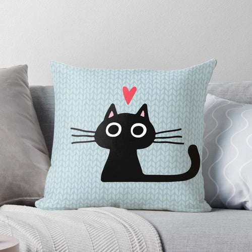 Soft, heart-shaped pillow featuring an illustration of a cute black cat kitten for Valentine's Day