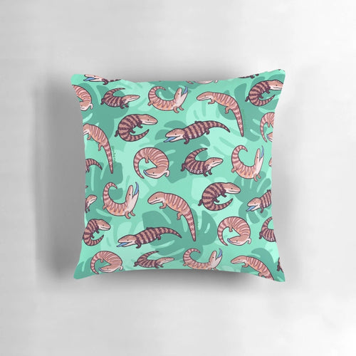 A vibrant and whimsical throw pillow featuring a playful cartoon illustration of a blue tongue skink.