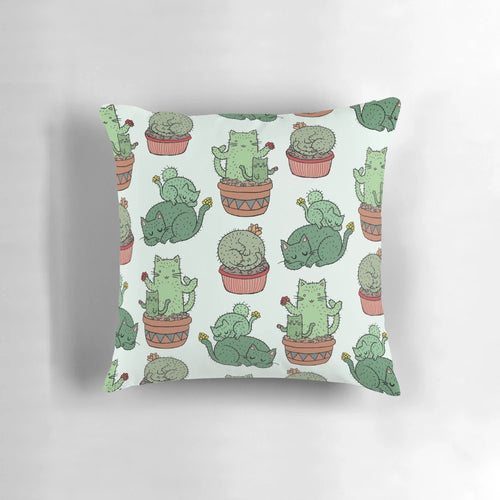 Cozy pillow featuring a playful design of cats among cactus plants