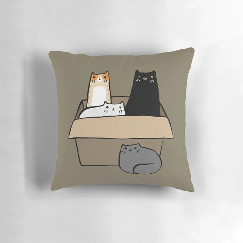 A decorative throw pillow featuring an illustration of various colorful cats in a cardboard box.