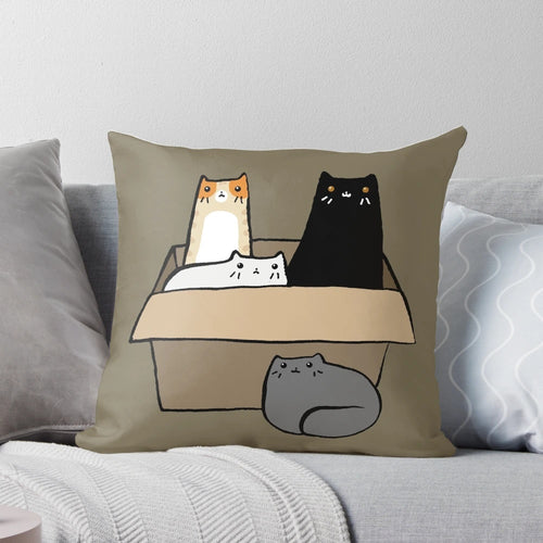 A decorative throw pillow featuring an illustration of various colorful cats in a cardboard box.