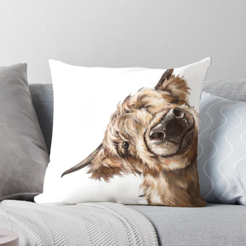 Soft, plush pillow featuring a playful highland cow with a big nose