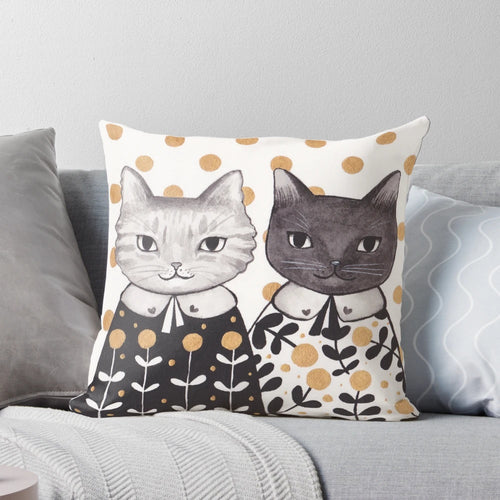 Colorful kitten pillow with capes in a floral pattern.