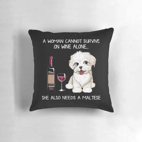 A fluffy white Maltese dog wearing a wine glass print bandana, resting on a decorative pillow.
