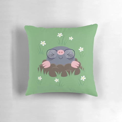 A decorative pillow featuring a pattern of cute, cartoon-style moles wearing eyeglasses and surrounded by grass and white flowers.