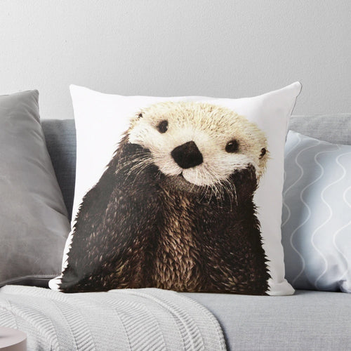 Soft, plush pillow featuring a playful otter with a big smile, perfect for adding a touch of whimsy to any room.