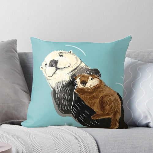 Soft, plush pillow featuring a cute sea otter mother and her baby otter snuggling on a river bank.