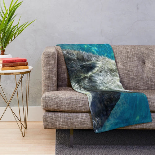 Soft and cuddly sea otter plush blanket with a cute blue water design