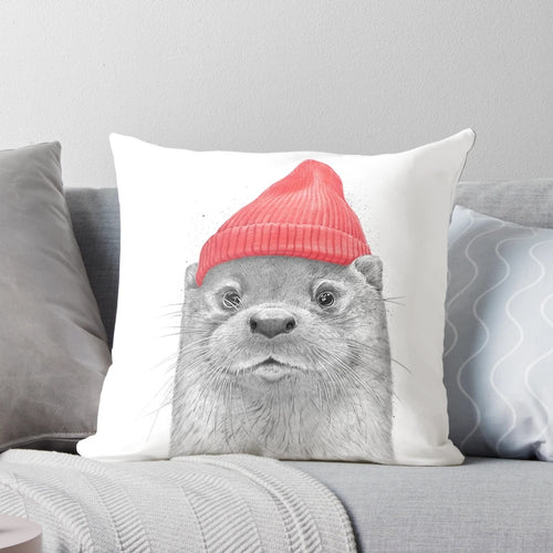 Soft, cuddly sea otter plush pillow with a red hat, perfect for snuggling and home decor.