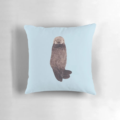 Soft, fluffy watercolor illustration of a baby sea otter on a decorative pillow