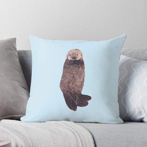 Soft, fluffy watercolor illustration of a baby sea otter on a decorative pillow