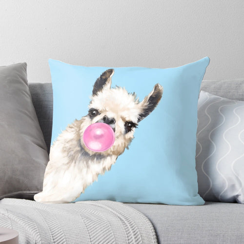 A cute and whimsical pillow featuring a sneaky llama blowing bubble gum in shades of blue and pink.