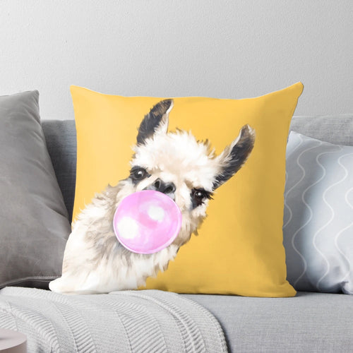 Mustard yellow pillow with a cute and sneaky llama blowing bubble gum