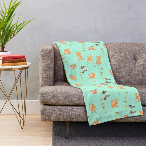 Toller puppy and duckling playing on a mint plush blanket with a sketch pattern design