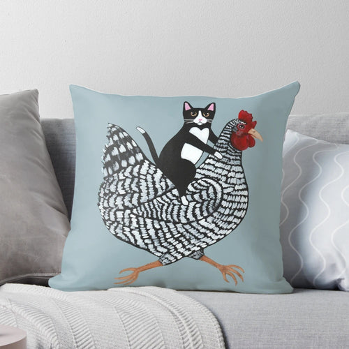 Tuxedo cat sitting on a chicken-shaped pillow, a humorous and cute home decor item.