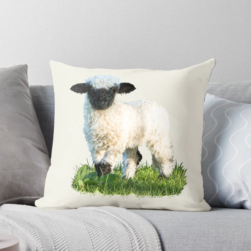 A soft, plush pillow featuring an adorable Valais Blacknose sheep lamb in a beautiful natural meadow setting.