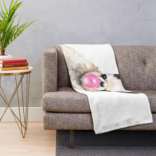 Watercolor illustration of a llama chewing bubble gum on a plush blanket