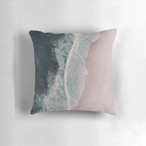 Aerial photograph of pink sand beach, crashing waves, and dark blue ocean