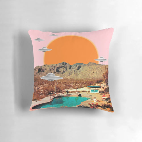 Throw pillow featuring a vibrant, photorealistic image of a UFO landing in a desert landscape with cacti and a pink sunset sky.