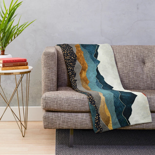 Soft and cozy amber plush blanket with a landscape design depicting a dusk sky over hills and mountains