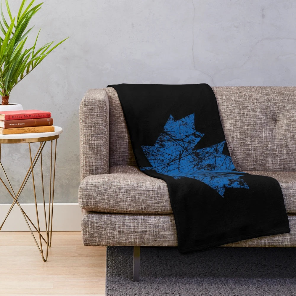 Blue plush blanket with a distressed Canadian maple leaf design
