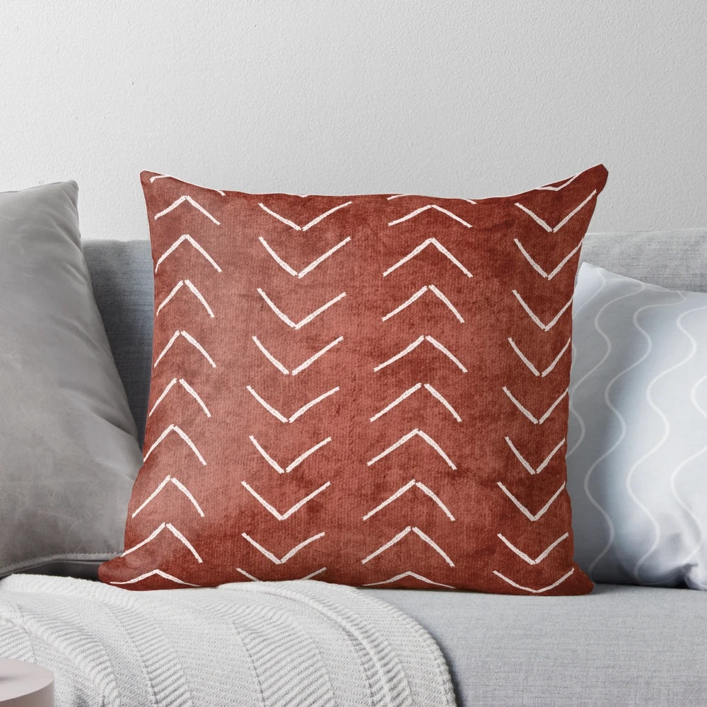 Decorative boho throw pillow with African mud cloth pattern in white and rust terracotta colors