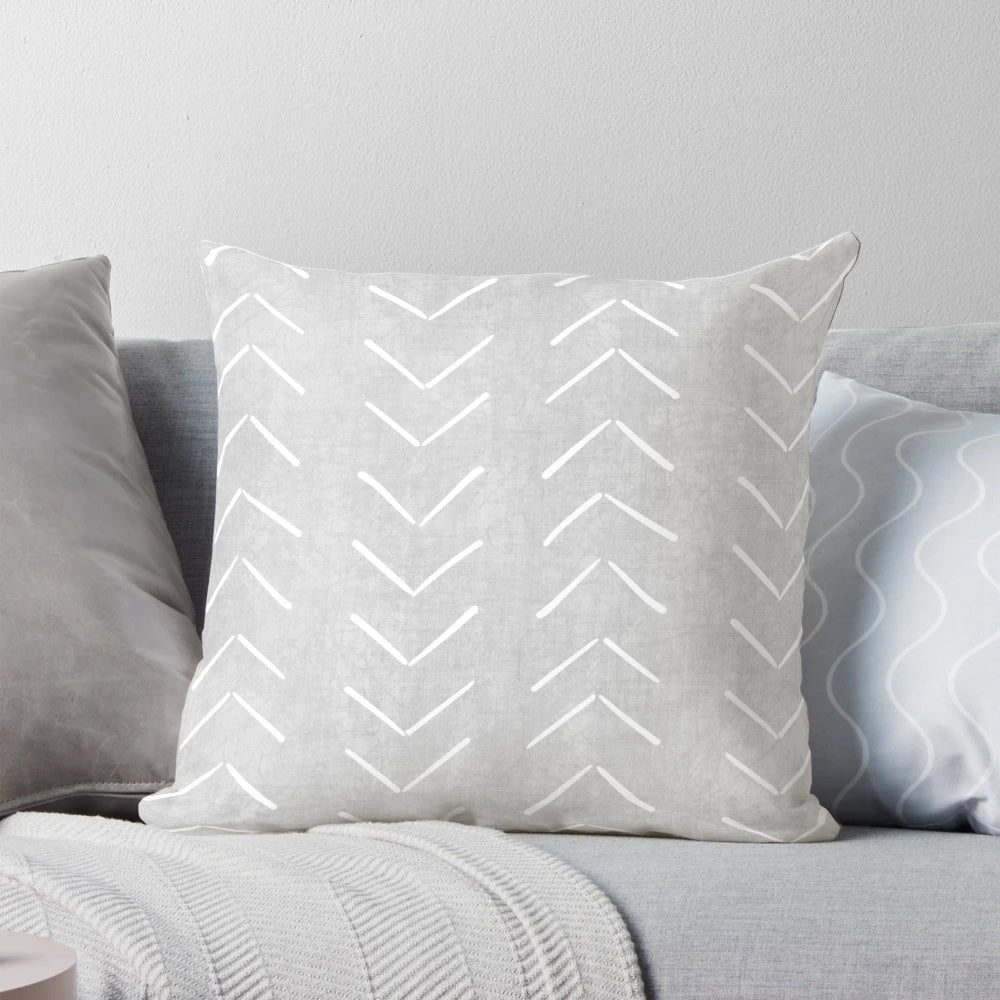 Boho-style grey and white throw pillow with geometric arrow design