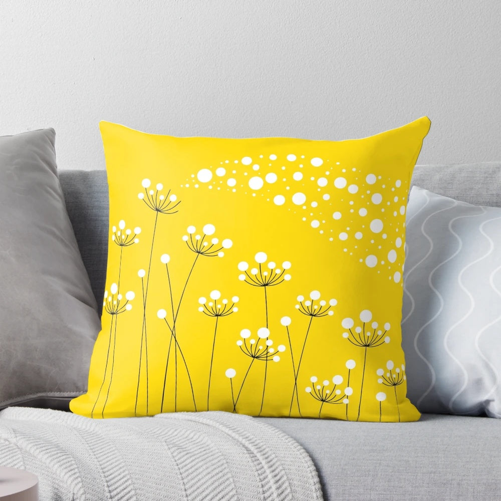 A stylish and minimalist throw pillow featuring a graphic design of dandelion silhouettes against a yellow background.
