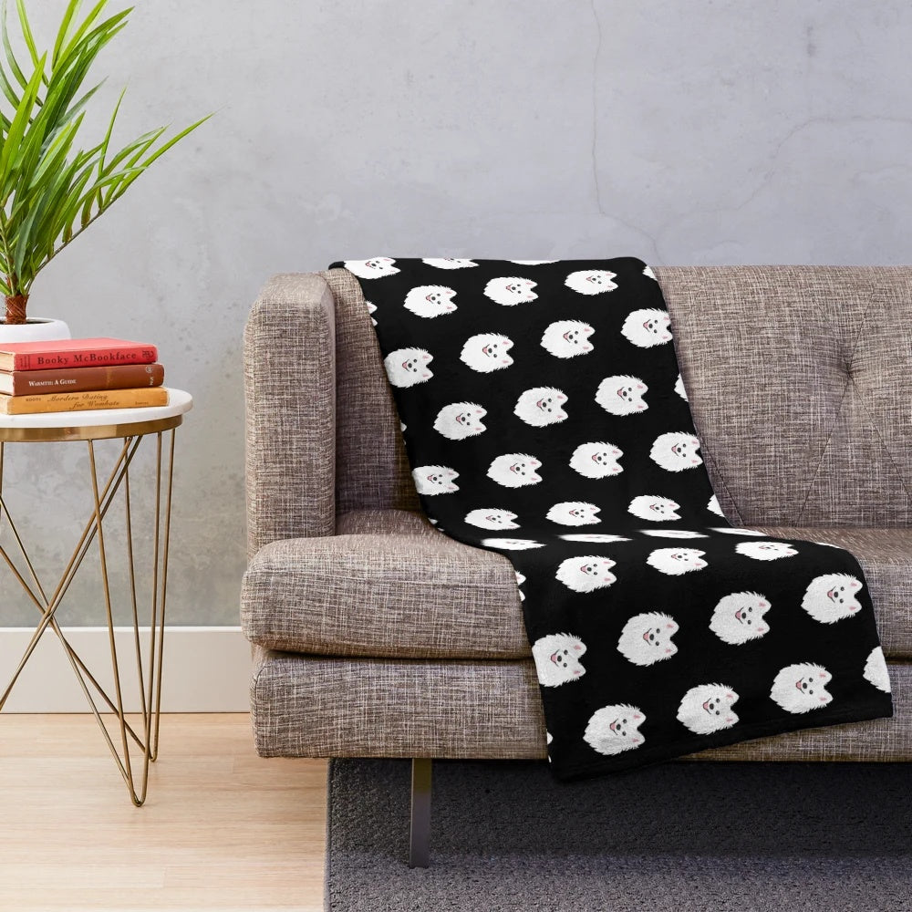Curious white spitz puppy dog on charcoal black plush blanket