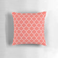A plush, living coral quatrefoil-patterned pillow with a modern, elegant design.