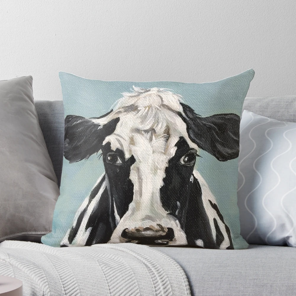 A vibrant black and white cow painting on a decorative throw pillow for farmhouse-style living spaces.