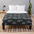 Soft and warm plush blanket featuring a repeating raccoon pattern design