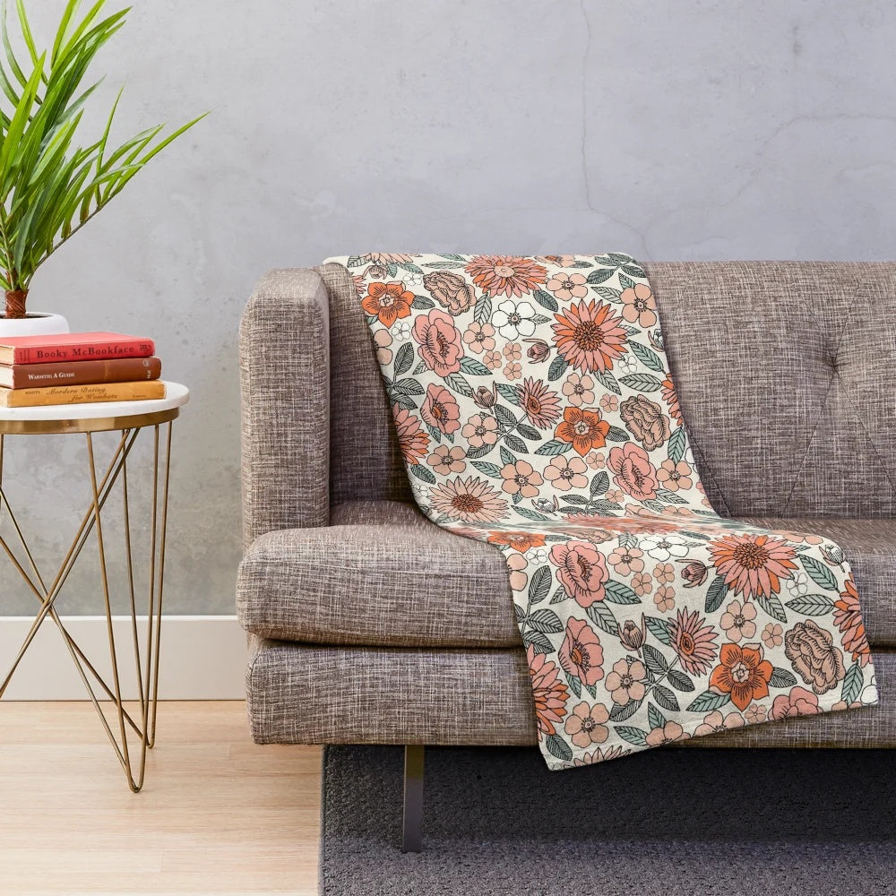 Soft and inviting plush blanket featuring a 70s inspired floral pattern in muted, earthy tones