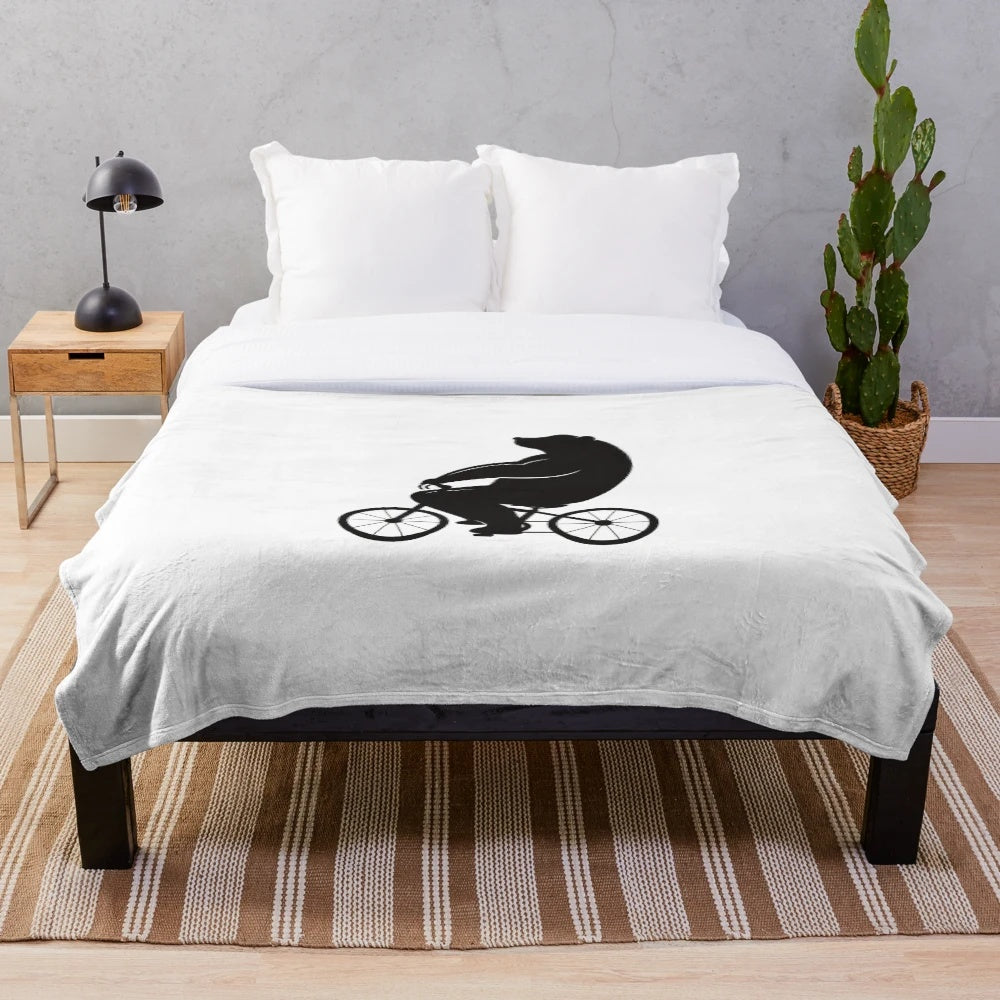 Plush blanket featuring a cute bear riding a bicycle