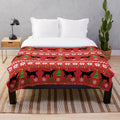 Black labrador retriever wearing reindeer antlers on a plush Christmas blanket