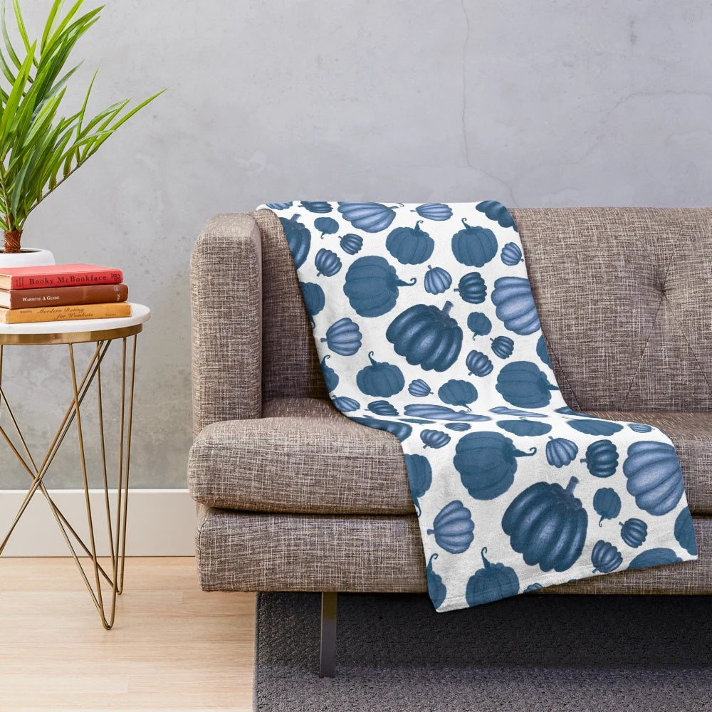 Blue pumpkin pattern on a plush white blanket