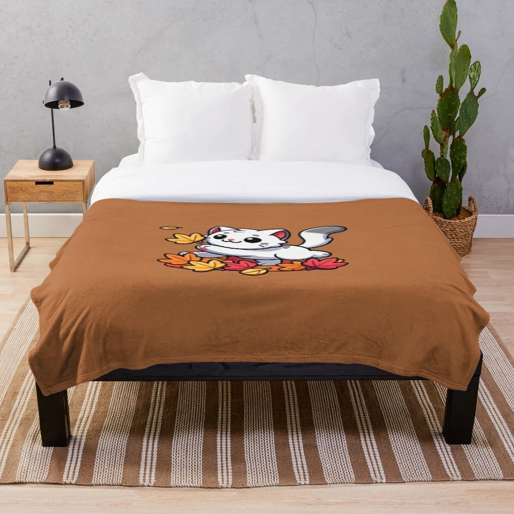 Cute cartoon cat playing with autumn leaves on a plush blanket