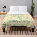 Plush blanket with a cinema-themed pattern featuring movie elements like popcorn, cameras, and retro drinks.