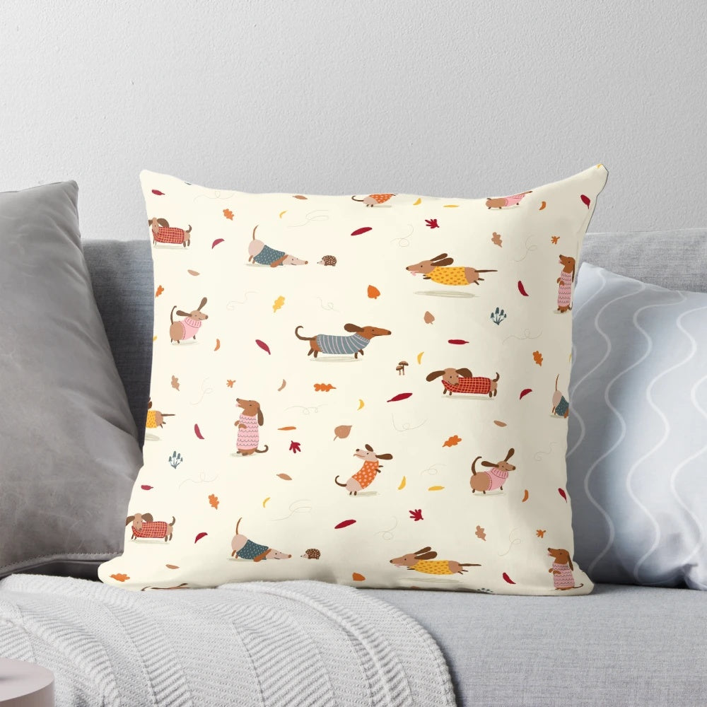 Cute dachshund wearing a winter sweater surrounded by autumn leaves on a decorative pillow