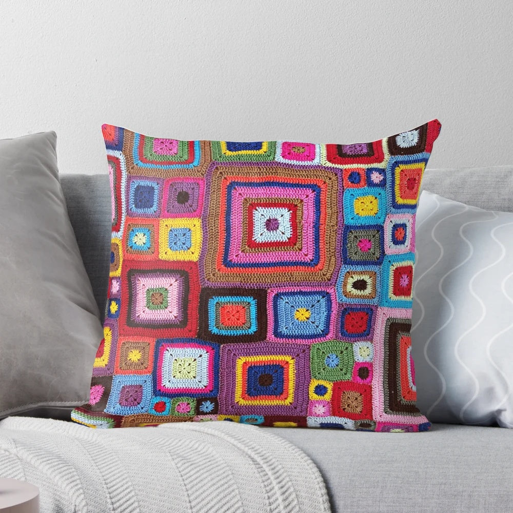 A cozy, handmade crochet pillow in a vibrant vintage granny chic style.