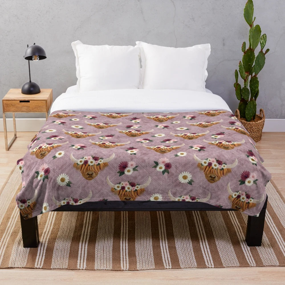 Floral crowned highland cows printed on a mauve plush blanket
