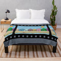 Cozy movie-themed plush blanket featuring digital artwork of houses, sun, beach, and cinema