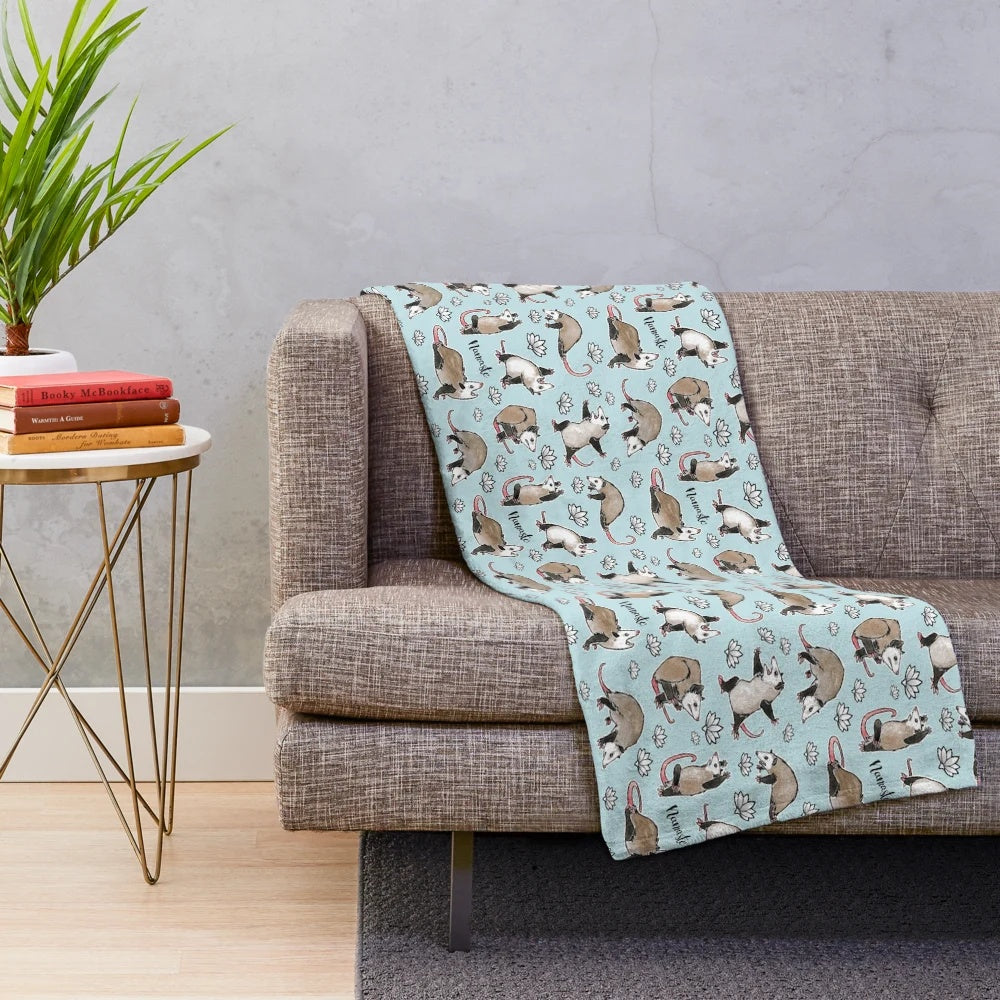 Cozy aqua plush blanket featuring cute opossums in yoga poses