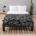 Plush blanket featuring a paleontology-inspired design with dinosaur fossils and skeletons