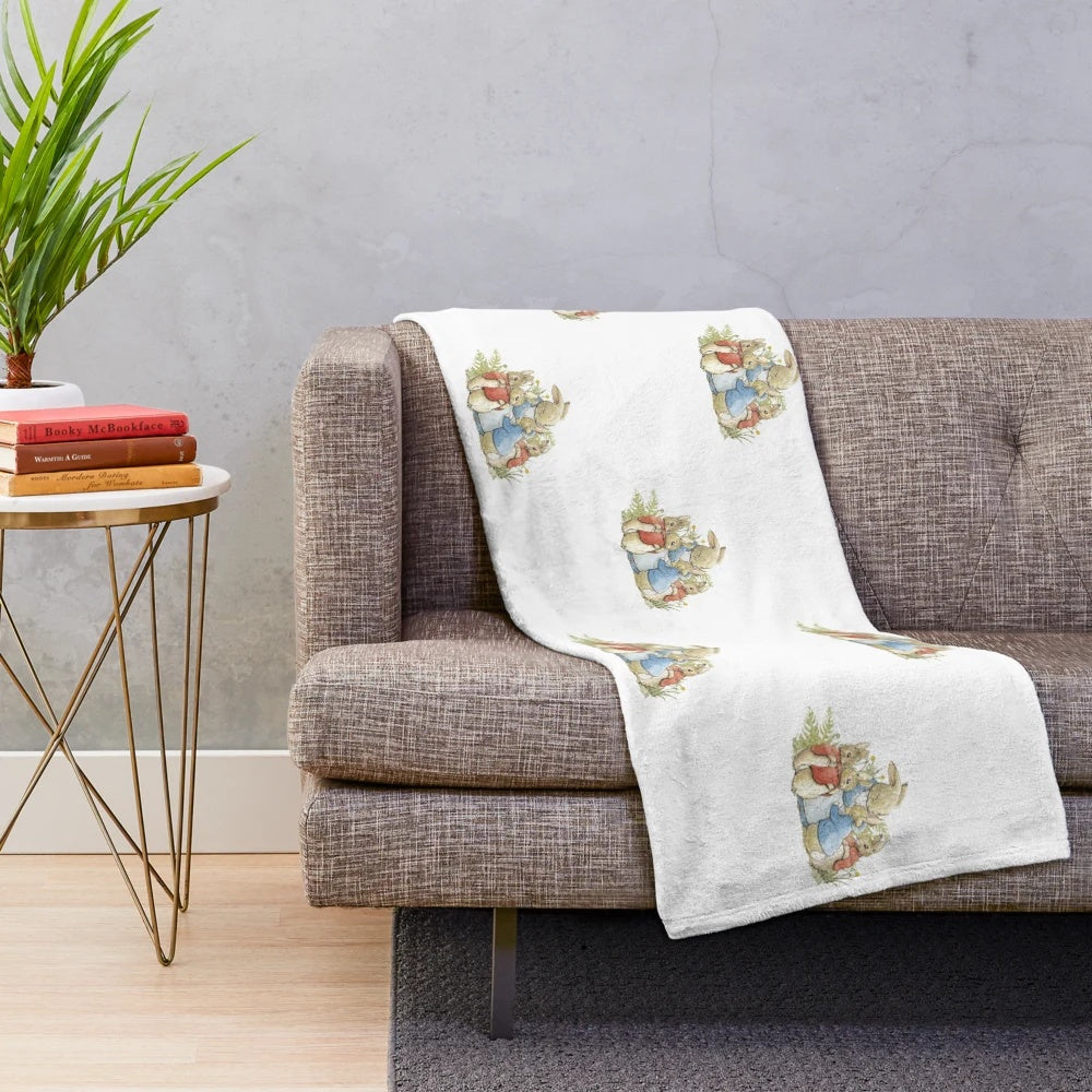 Plush blanket with illustration of Peter Rabbit and his family