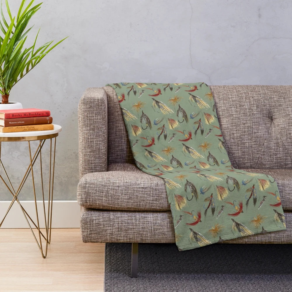 Plush blanket featuring hand-tied fishing flies and woodland design