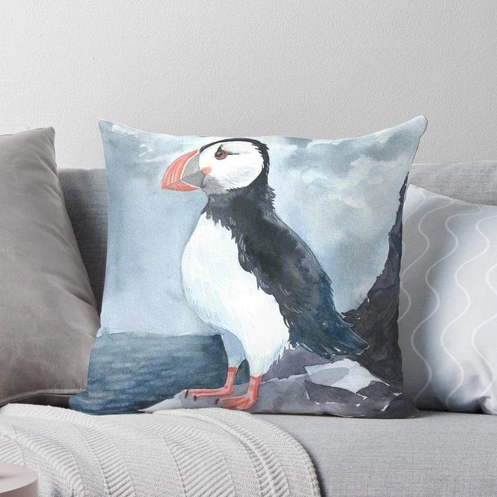 Soft, plush pillow featuring a beautiful watercolor painting of a puffin bird, perfect for adding a touch of Icelandic charm to your home.