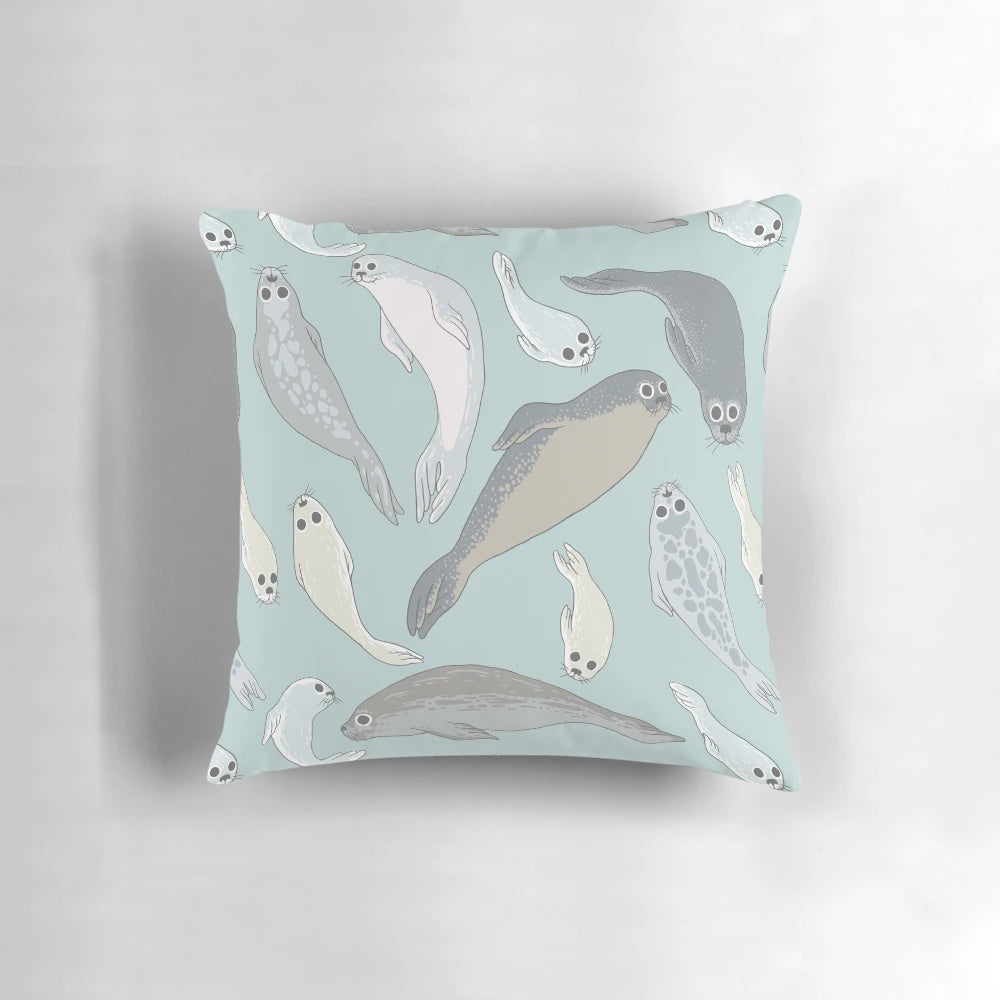 A soft, plush pillow shaped like a baby seal with realistic fur and features.