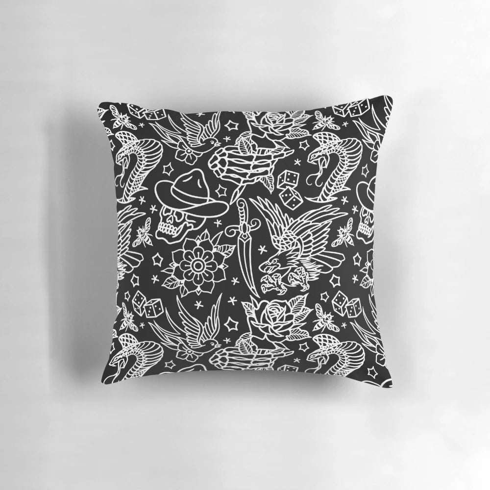 Decorative throw pillow featuring a collage of American traditional tattoo designs including eagle, skull, flower, dagger, snake, rose, sparrow, bee, skeleton hand, and dice.