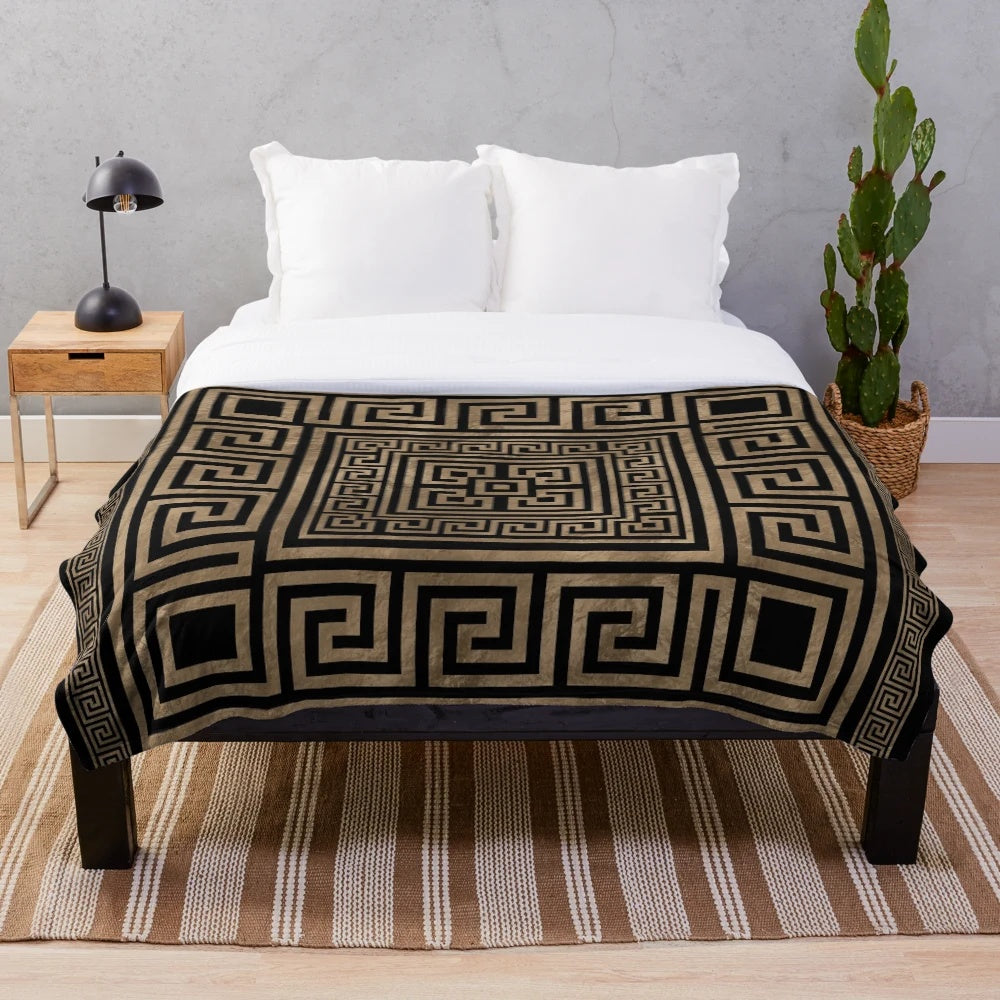 Greek key meander pattern printed on a black and gold plush blanket